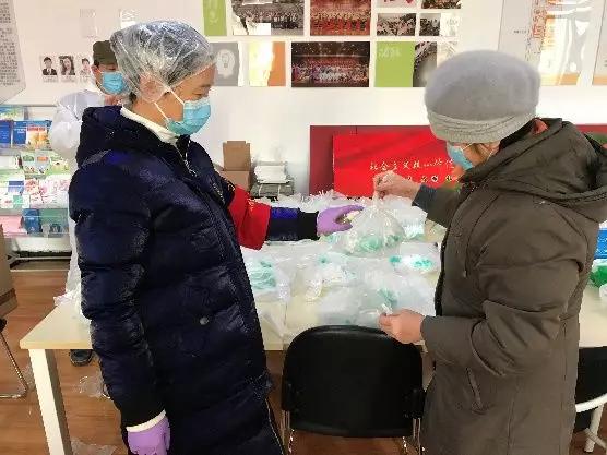 為樓棟分發(fā)口罩，并為包裝袋消毒